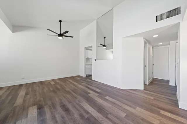 a view of empty room with wooden floor