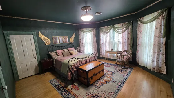 a bed sitting in a bedroom next to a window