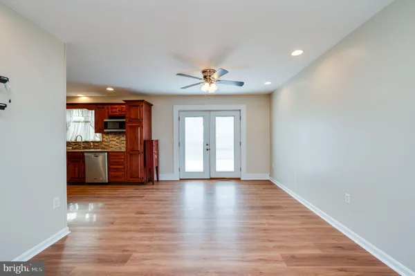 a view of an empty room with a kitchen and a window