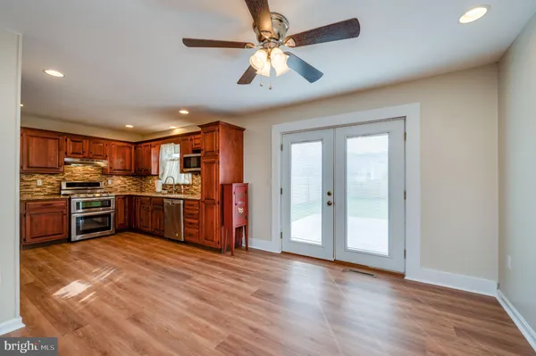 a kitchen with stainless steel appliances kitchen island granite countertop a refrigerator and a stove top oven