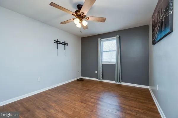 a view of a big room with wooden floor and a chandelier fan