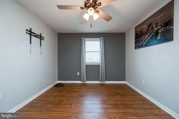 a view of an empty room with window and wooden floor