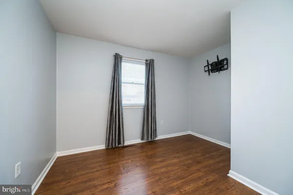 an empty room with wooden floor and closet