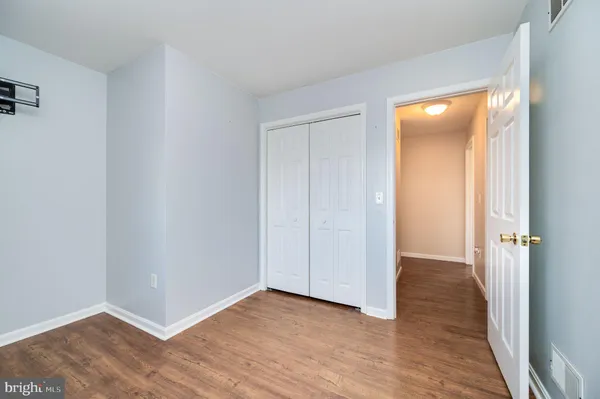 an empty room with wooden floor and closet