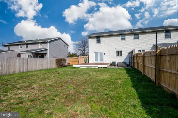 a view of backyard with barbeque grill potted plants and wooden fence