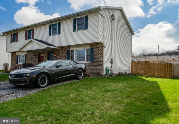 a car parked in front of a house and a yard