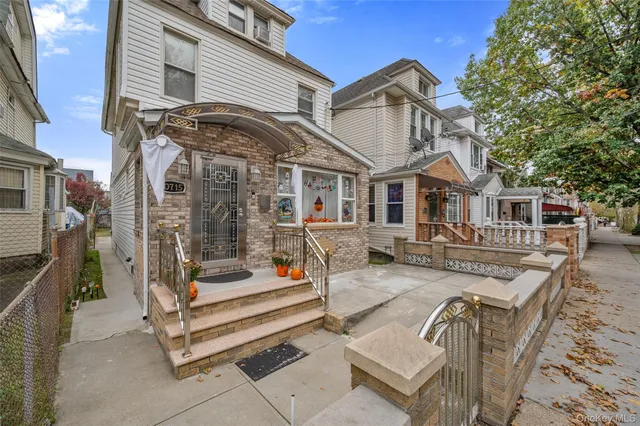 a view of a white house with a large windows and couches chairs