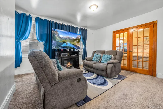 a living room with furniture a large window and a flat screen tv