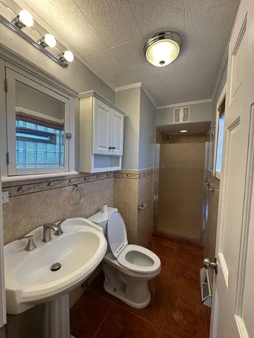 a bathroom with a toilet sink and mirror