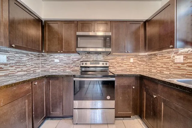 a kitchen with stainless steel appliances wooden cabinets a sink and a stove