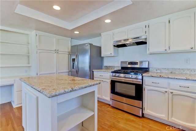 a kitchen with kitchen island a sink stove and refrigerator