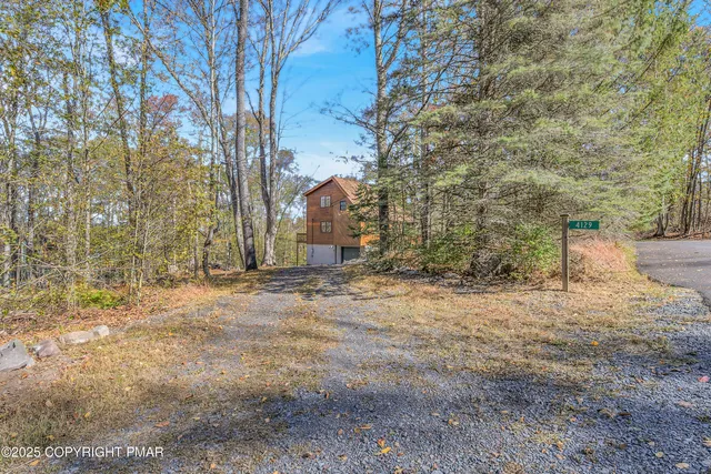 a kitchen with stainless steel appliances granite countertop a stove top oven a sink a dining table and chairs with wooden floor