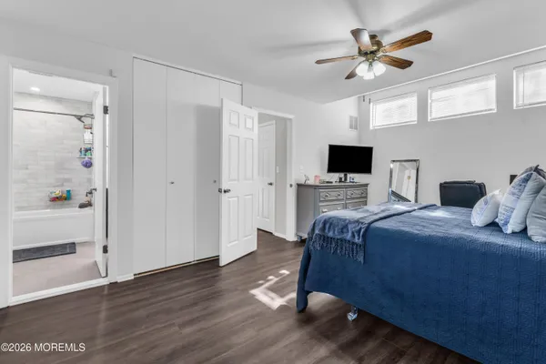 a bedroom with a bed a flat screen tv and a window