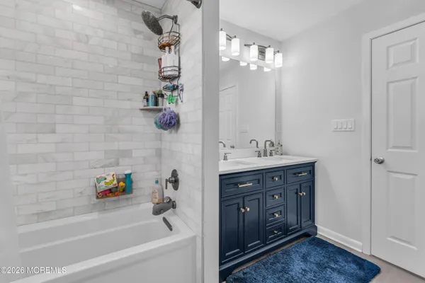 a bathroom with a tub sink and mirror