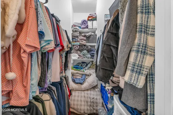 a view of walk in closet with clothes and shoes