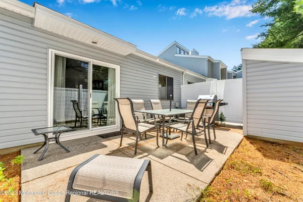 a view of a patio with table and chairs with wooden floor and fence