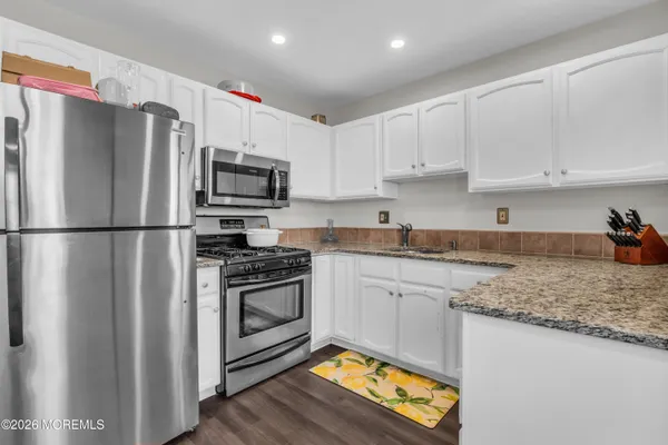 a kitchen with granite countertop a refrigerator stove and microwave