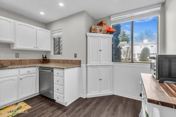 a open kitchen with granite countertop a sink cabinets and wooden floor