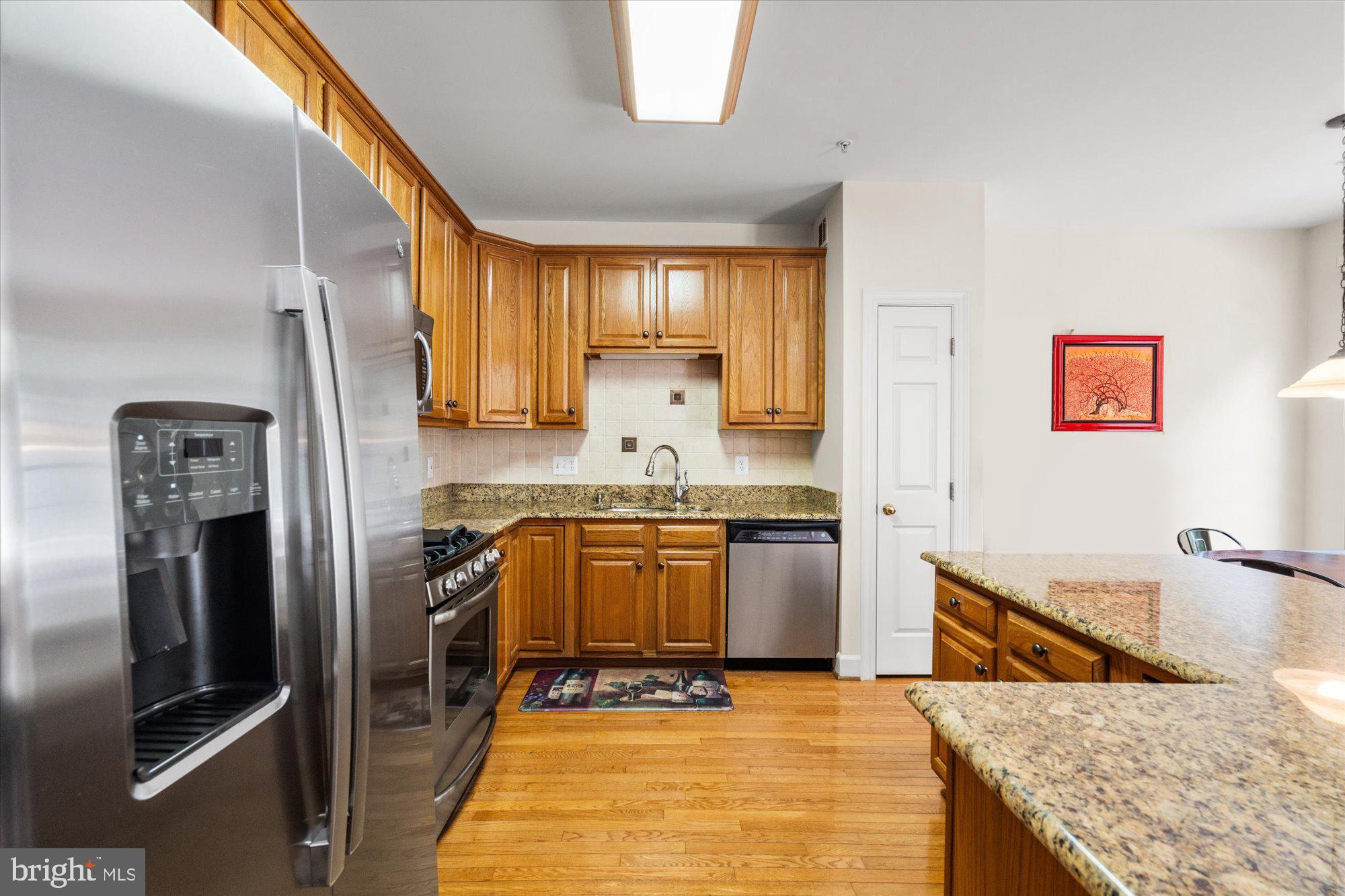 8510 Bells Ridge Terrace Potomac, MD 20854 - Photo 11 of 42 a kitchen with granite countertop a refrigerator stove and sink
