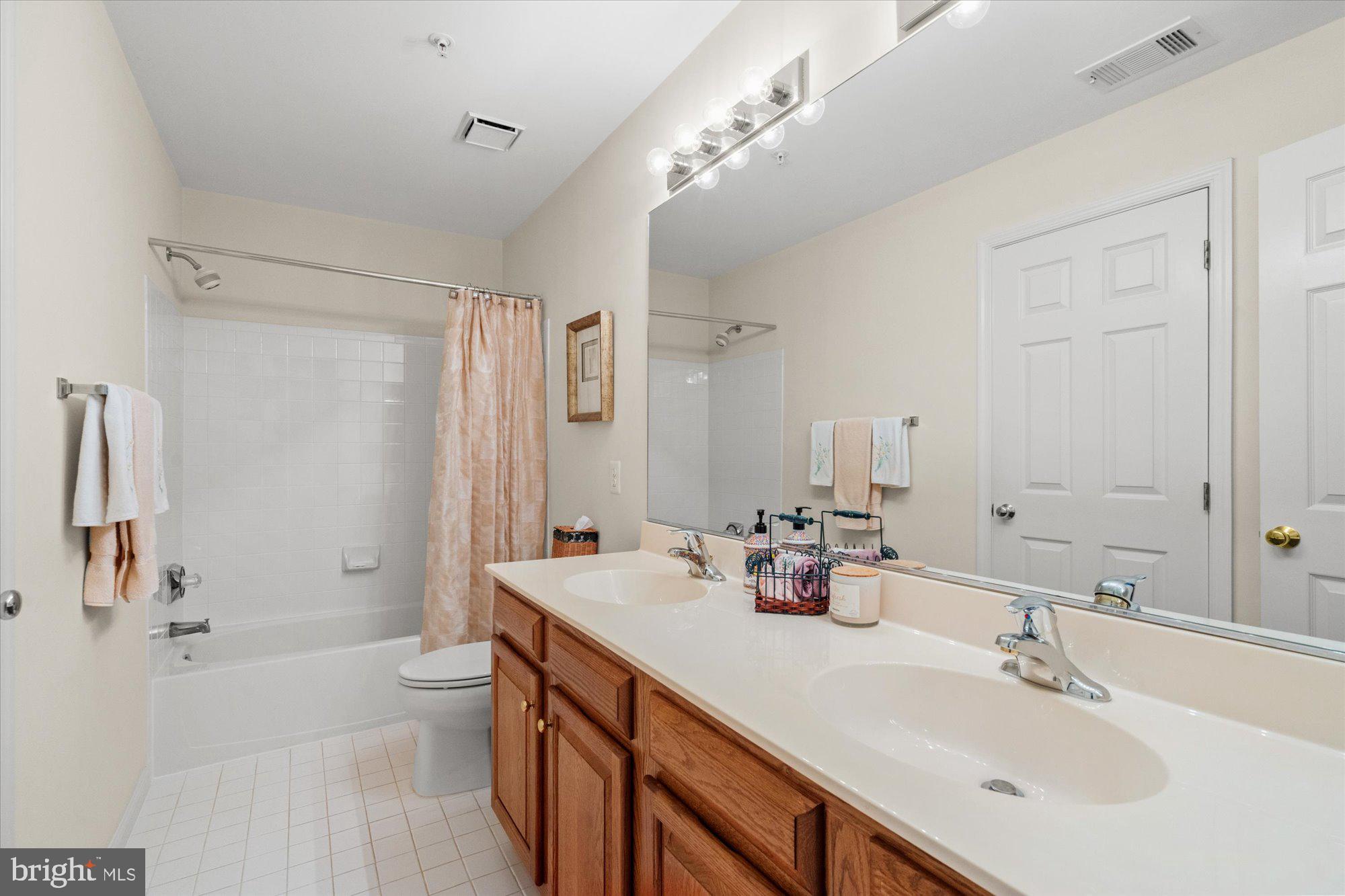 8510 Bells Ridge Terrace Potomac, MD 20854 - Photo 25 of 42 a bathroom with a double vanity sink toilet mirror and bathtub
