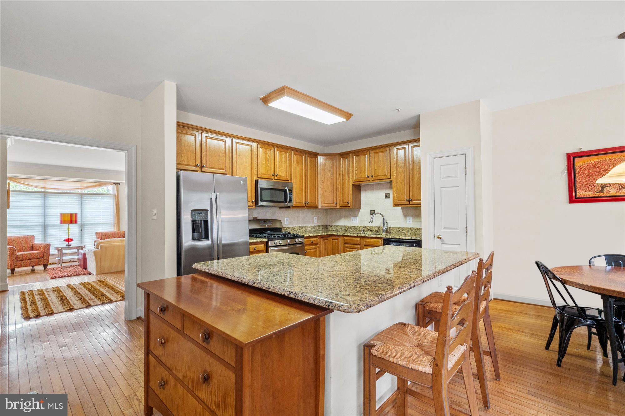 8510 Bells Ridge Terrace Potomac, MD 20854 - Photo 10 of 42 a kitchen with a stove a sink a dining table and chairs