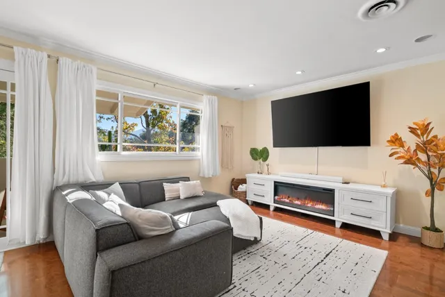 a living room with furniture a flat screen tv and a fireplace