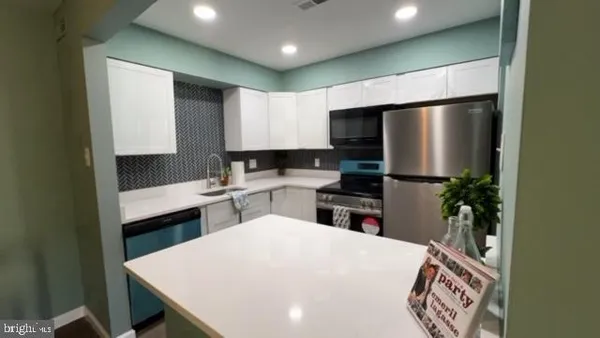 a kitchen with stainless steel appliances a refrigerator sink stove microwave and cabinets