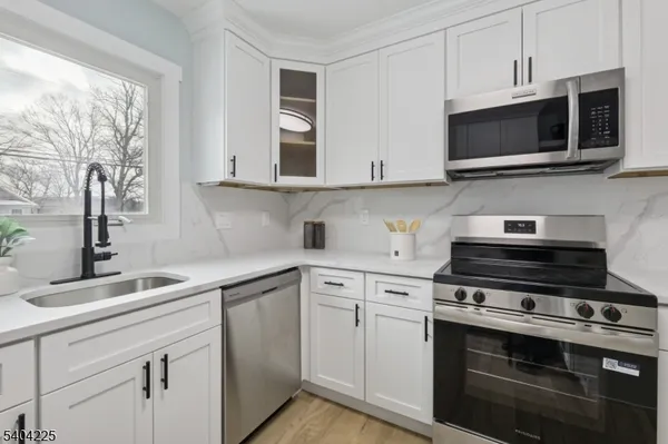 a kitchen with stainless steel appliances granite countertop a sink and a stove