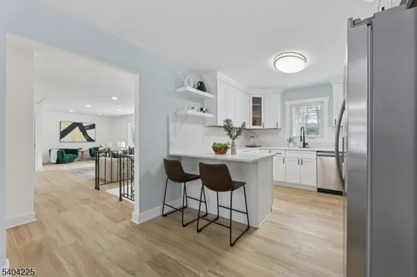 a view of a room with wooden floor table and windows