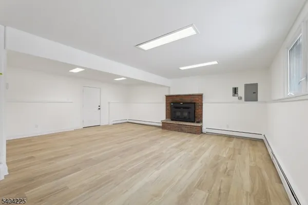 an empty room with wooden floor and a fireplace