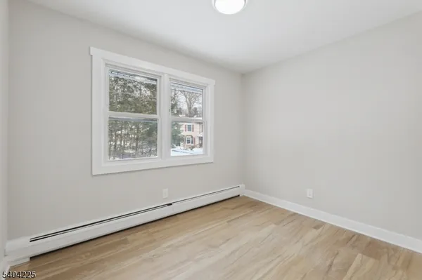 a view of a livingroom with wooden floor and furniture