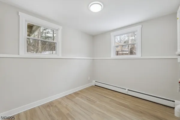 a view of a hallway with wooden floor and closet