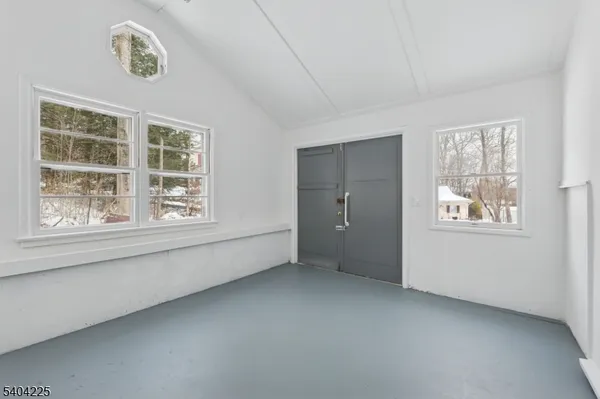 a view of a room that has a window and wooden floor