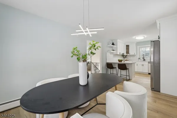 a kitchen with stainless steel appliances a refrigerator a stove a sink and chairs