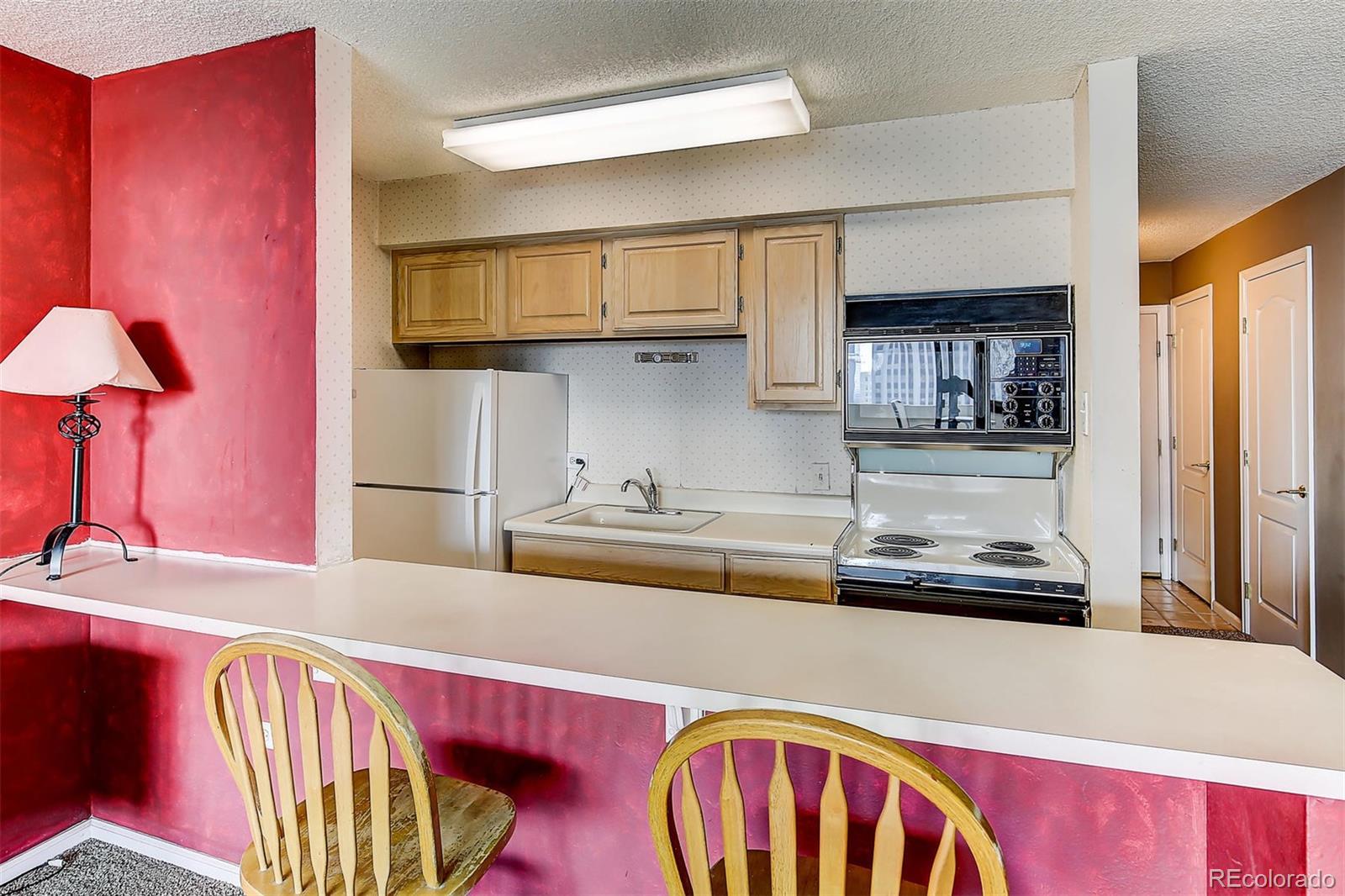 1020 15th Street, Unit 21I Denver, CO 80202 - Photo 4 of 27 a kitchen with stainless steel appliances granite countertop a refrigerator and a stove top oven