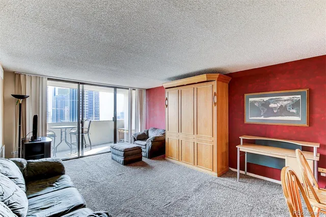 a living room with furniture a large window and a flat screen tv