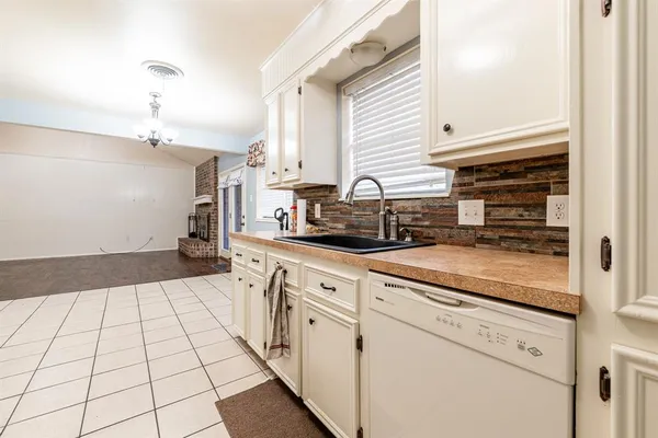 a kitchen with a sink a stove cabinets and a window