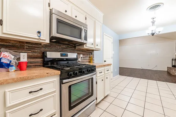 a kitchen with granite countertop a stove and a microwave