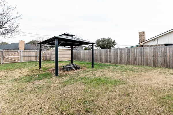 a view of a backyard with a garden and entertaining space