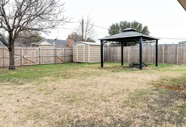 a view of a small yard with wooden fence
