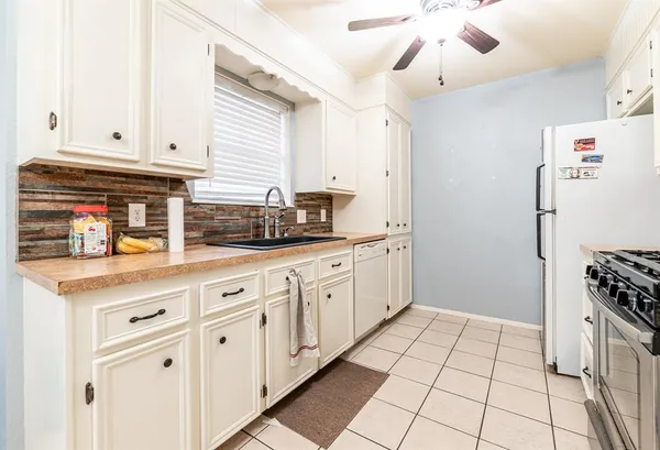 a kitchen with stainless steel appliances white cabinets and a window