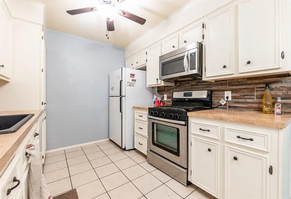 a kitchen with stainless steel appliances granite countertop a stove a microwave and a refrigerator