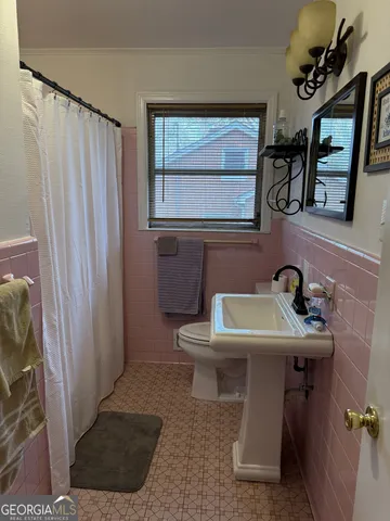 a bathroom with a sink a toilet and mirror