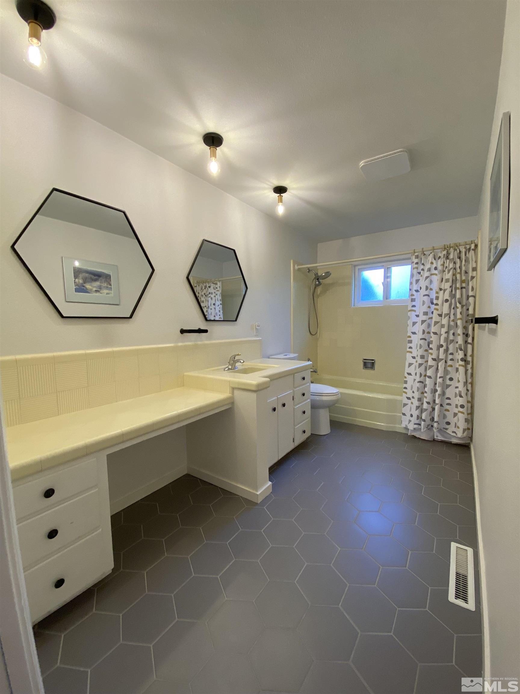 945 West 12th Street Reno, NV 89503 - Photo 17 of 29 a bathroom with a double vanity sink mirror and toilet