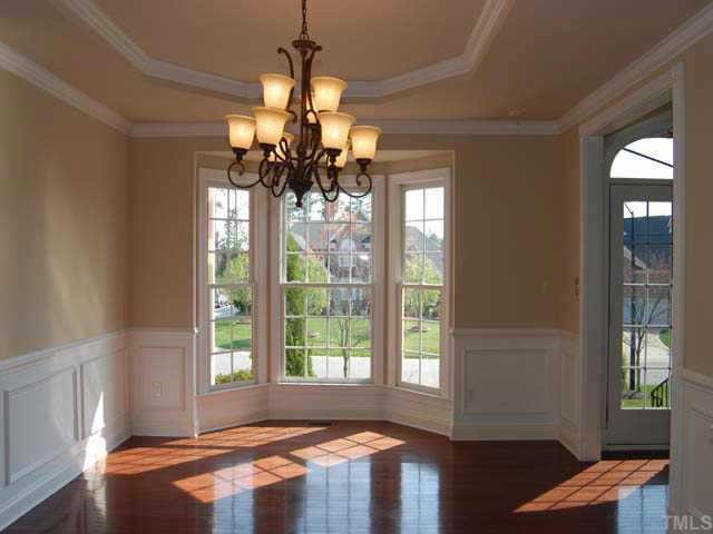 9308 Naples Court Raleigh, NC 27617 - Photo 3 of 12 An elegant dining room has a smooth trey ceiling, hardwood floor, designer neutral wall paint, painted chairrail, crown and wainscot molding, new upgraded chandelier, bay window and is pre-wired for surround sound speakers Other
