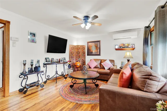 a living room with furniture and a flat screen tv with kitchen view