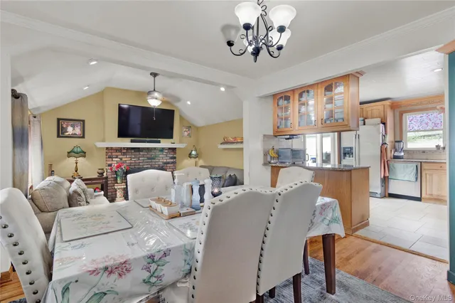 a living room with furniture a flat screen tv and kitchen view