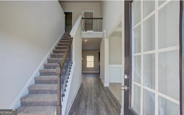 a view of a hallway with wooden floor and entryway