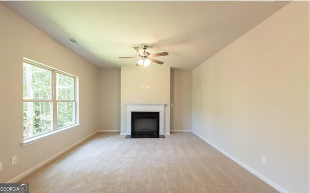 an empty room with a fireplace and windows