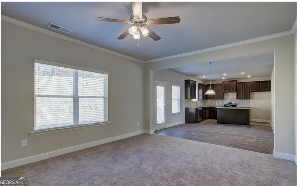 a view of a livingroom with a ceiling fan and window